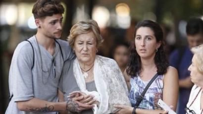 Señora herida asistida por dos jóvenes.